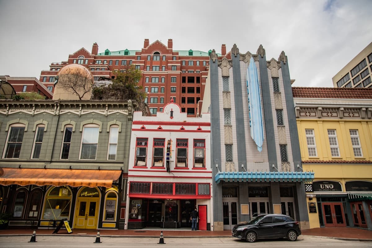 A car is parked in front of a row of buildings — Fort Worth, TX