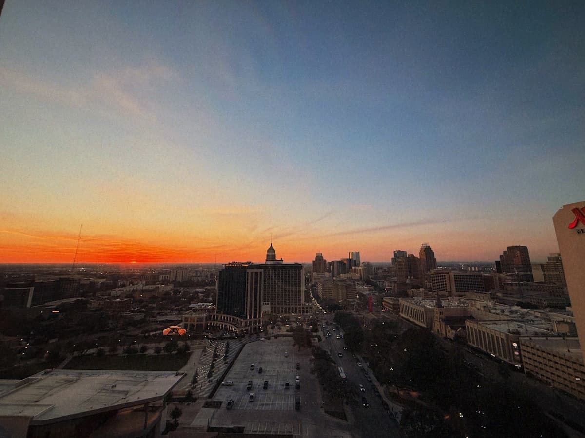 City skyline at sunset with vibrant orange sky — San Antonio, TX