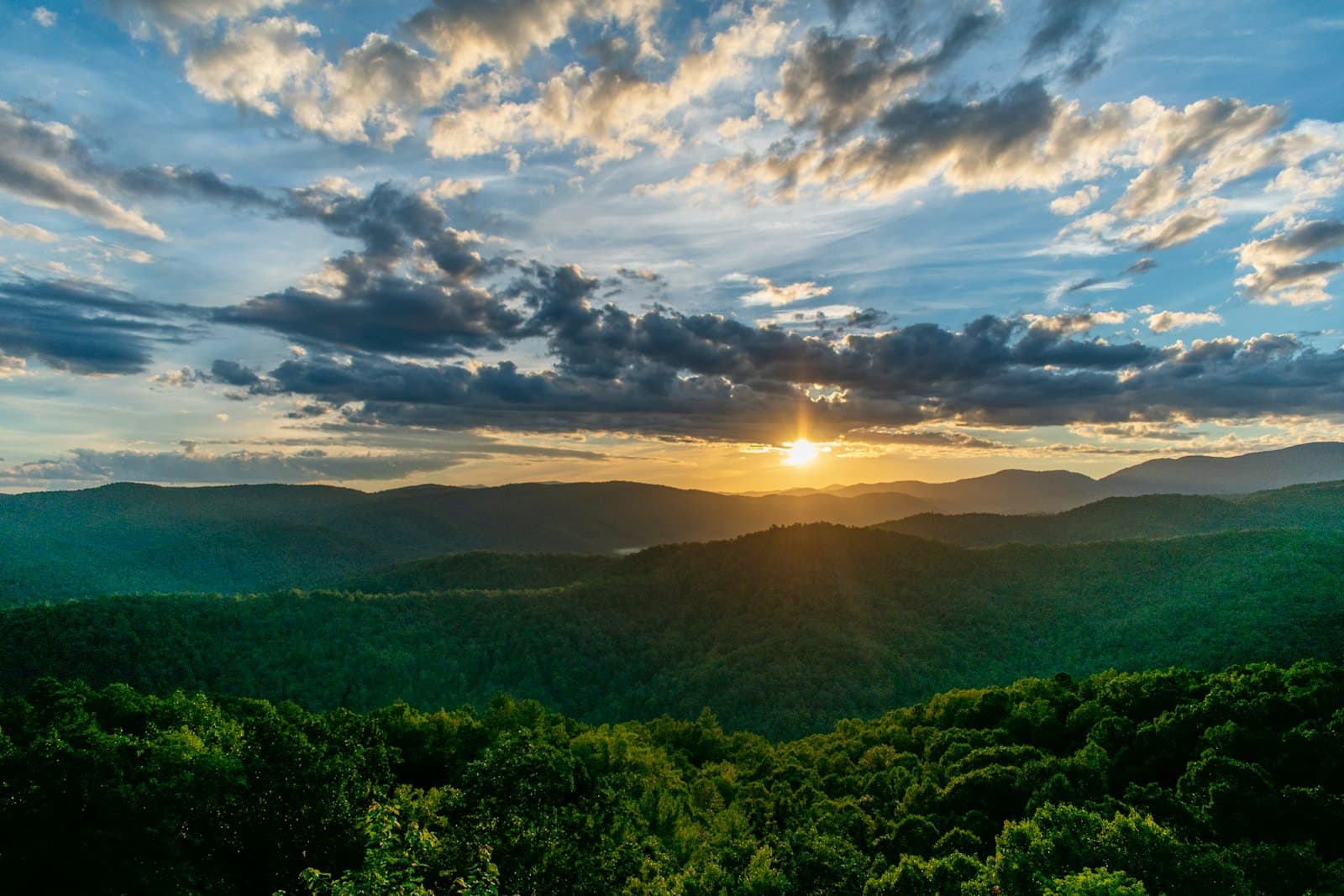 green trees and mountains during sunrise — Southeast